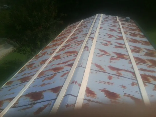 Rusted metal roof panels with new wood purlins before replacement — Storm Damage Roof Repair in Reinholds by Roofing Brothers