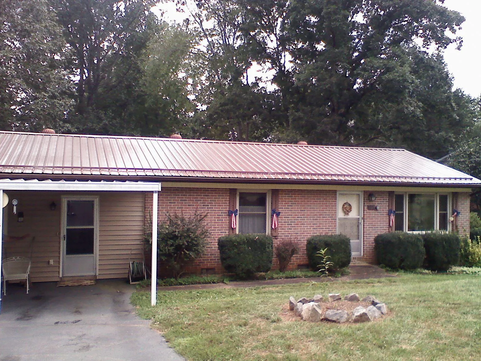 Bronze metal roof and carport on a brick ranch home — Roof Repair work by our crew in Reinholds