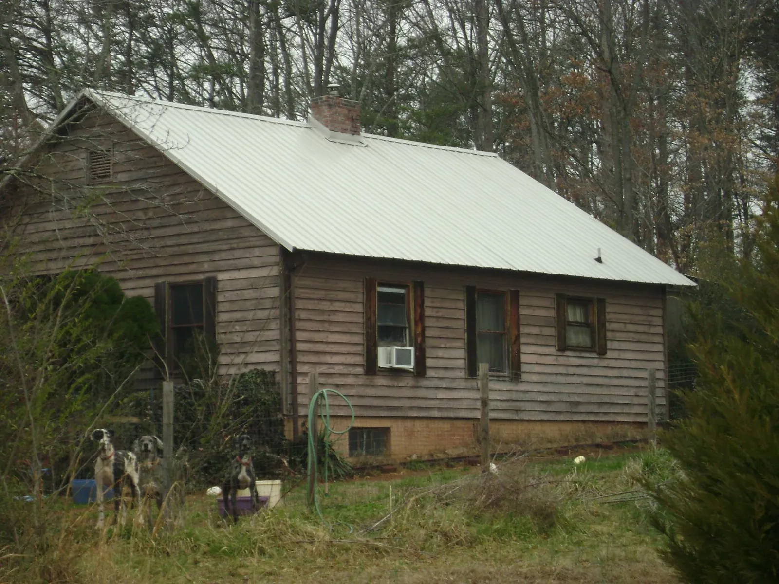 White metal roof on an old wood sided farmhouse, from a Metal Roof Installation job in Reinholds